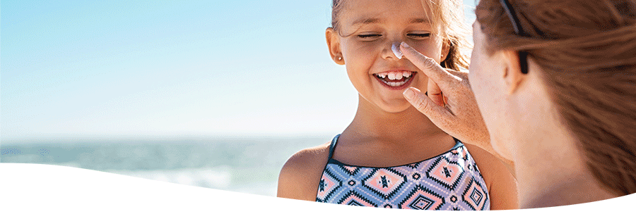 Kind und Mutter mit Sonnencreme